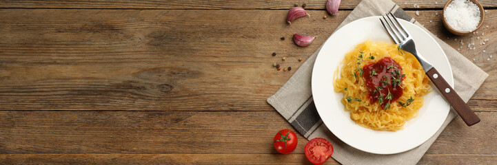 Tasty spaghetti squash with tomato sauce and thyme served on wooden table, flat lay. Banner design with space for text