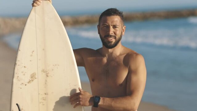 Surfer checks his board and shows shaka gesture