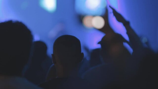 People enjoy a live concert in blue lighting