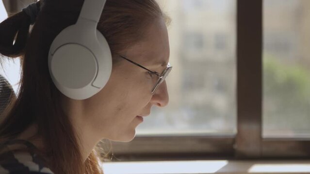 Adult womans face with headphones in profile