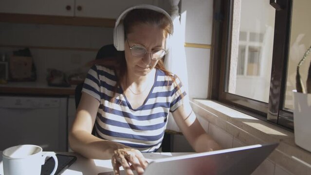 Adult woman works at computer at home