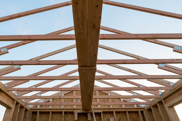 Fototapeta premium Roof support beams and wood studs framing in new home construction