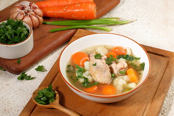 Homemade chicken soup with vegetables in a white bowl.Healthy warm comfortable food.