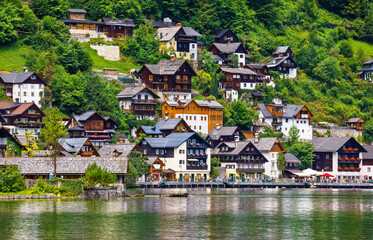 Fototapeta na wymiar Hallstatt, Austria. View to Hallstattersee Lake and Alps mountains. Ancient houses at lake banks. Summer day. Blue sky with clouds.