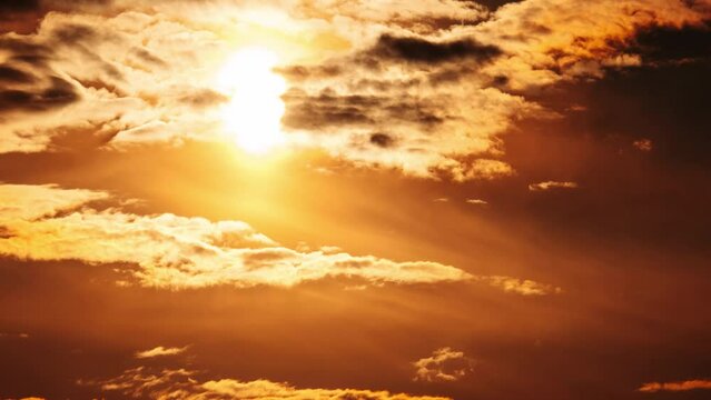 Awesome sunset moving down in orange sky with clouds, Timelapse. Bright orange sun moves down over the horizon behind the layered clouds. Epic cloud space, vibrant color. Time Lapse. Beautiful sundown