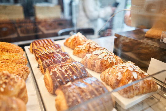 A variety of fresh pastries in the bakery window. almond croissant is fresh and hot in a cafe next to other types of pastries. The interior of an Italian restaurant.