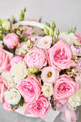 Flower arrangement in Wicker basket. Beautiful bouquet of mixed flowers on a marble table. Floral shop concept . Handsome fresh bouquet. Flowers delivery