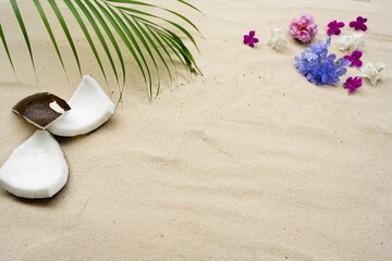 Coconut on palm leaves and flowers on the beach.                              
