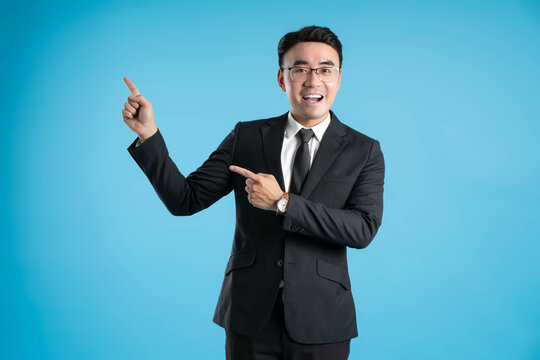  image of young businessman posing on blue background