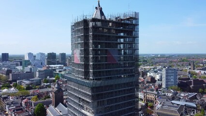 Establishing  aerial view St Martins Cathedral Dom tower covered in scaffolding for restoration to reveal Utrecht city landscape