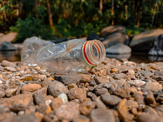 Obraz premium An used trash bottle on stone street. An used plastic bottle. Environmental pollution problem