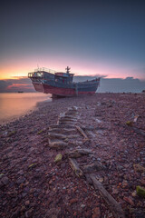 Abandoned fishing boat on the beach at sunset, Batam Island Indonesia - 616007116