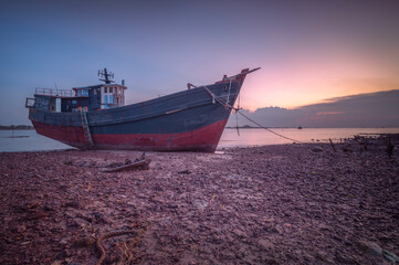 Abandoned fishing boat on the beach at sunset, Batam Island Indonesia - 616007175