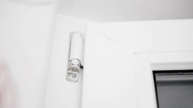 Upper door hinge of a plastic door close-up. Frequent door opening and closing