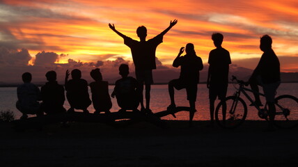 Silhouette of a group of people by the lake with a beautiful sunset