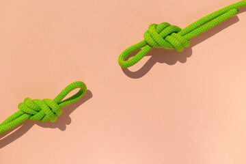 climbing rope with a knot lies on a colored background. the concept of reliability and safety. two...