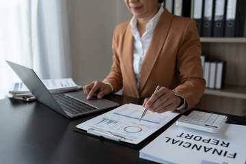 Businesswoman analyzing income charts and graphs with laptop computer. business analysis and...