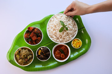 Kerala special food sadhya in banana leaf plate with Chicken fry Duck roast Beef fry Fish curry Cabbage thoran. Festival food for Christmas Easter celebration Kerala India Sri Lanka 