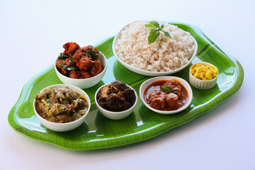 Kerala special food sadhya in banana leaf plate with Chicken fry Duck roast Beef fry Fish curry Cabbage thoran. Festival food for Christmas Easter celebration Kerala India Sri Lanka 
