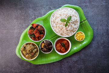 Kerala special food sadhya in banana leaf plate with Chicken fry Duck roast Beef fry Fish curry Cabbage thoran. Festival food for Christmas Easter celebration Kerala India Sri Lanka 