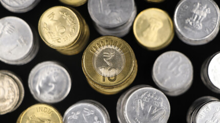 top view closeup shot of indian rupee coins in gold and silver arranged closely stacked in rows...