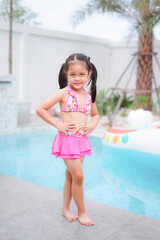 Young girl wearing pink swimsuit summer fashion.