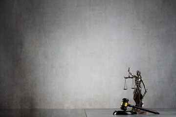 Law symbols composition. Gavel, scale and Themis sculpture on the gray background.