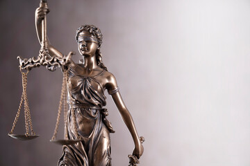 Law symbols composition. Gavel, scale and Themis sculpture on the gray background.