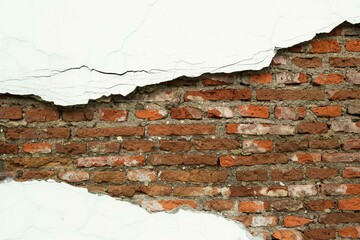 Old red brick wall with peeling plaster