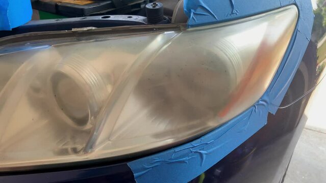 Car headlight being prepared to be treated for oxidation