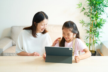 タブレットPCの画面を見る笑顔の親子