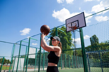 Athletic female basketball player throwing a ball up to the net.