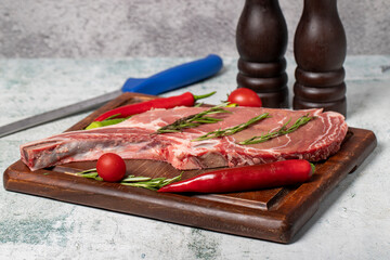 Raw veal chops. Fresh veal rib boned raw chops on wood serving board