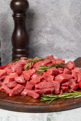 Raw beef meat chopped in cubes. Diced beef or lamb on a wooden serving board