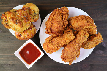 Mouthwatering Crispy Fried Chickens with Aromatic Herb Biscuits Served on Wooden Table