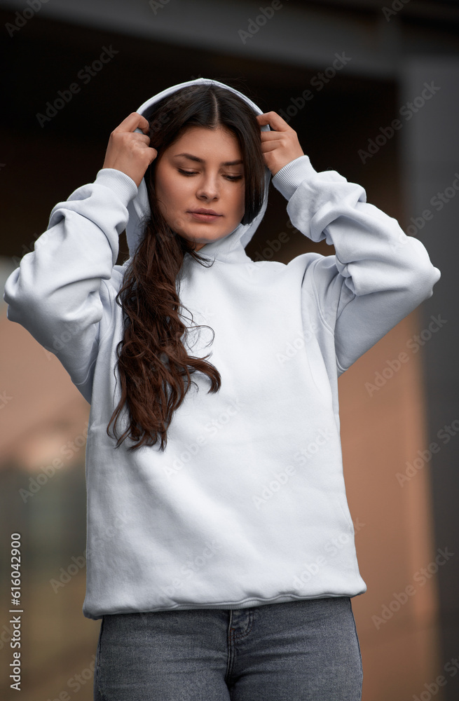 Sticker woman showcasing a white hoodie for logo branding. streetwear clothing mock-up. logo on shirt templa