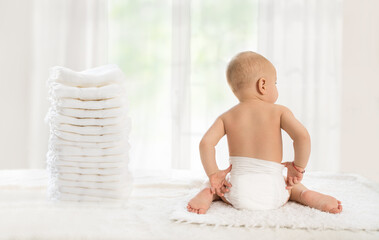 Back view of baby in comfortable disposable diapers - obrazy, fototapety, plakaty