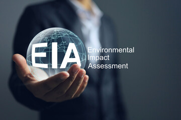 Businessman holding EIA approval or environmental impact assessment, taking into account the environmental impact of every process of the project from inception to use.