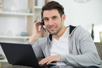 young smiling male call center operator doing his job