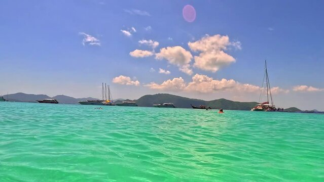 Kho Corel island off the coast of phuket thailand by speed bias from Chalong Bay, beautiful turquoise Blue beach with white soft sand and lush green trees 