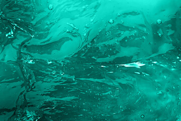 The texture of a mint color cosmetic gel with bubbles