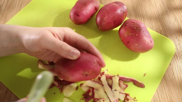 vegetable preparation. men's hands are peeling potatoes. close-up. sunny day. High quality 4k footage