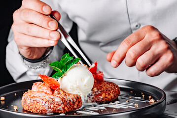 chef hand decorated cheese pancakes with ice cream and sweet sauce