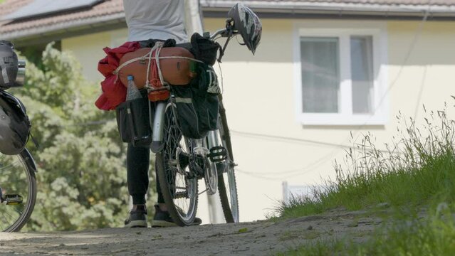 Cyclist Standing Beside Touring Cycle With Pannier Bags Attached On Rear Wheel. Low Angle, Slow Motion