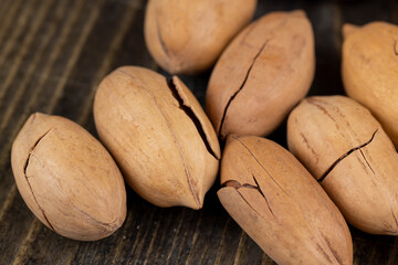 cracked unpeeled pecans close-up on the table