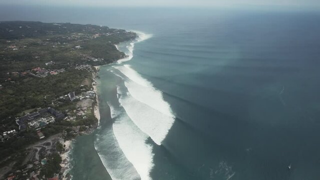 drone fly above bali island coastline indonesia with huge big ocean waves surfer travel destination 