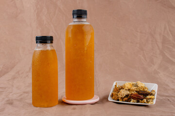 Cold water of chrysanthemum flowers and dried chrysanthemum flowers on brown background.