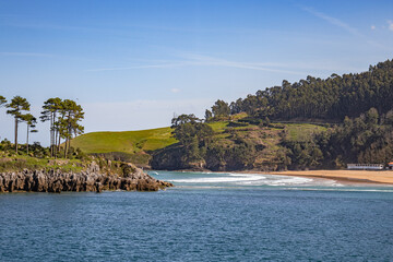 Lekeitio beach and little island of San Nicolas in Basque country, hills and forests around