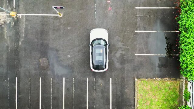 Top down video white mini cooper driving alone. Empty airport parking. Smart car driving.
