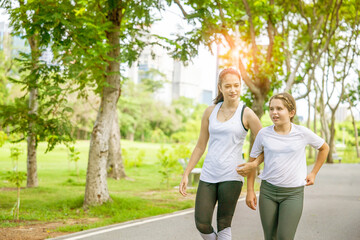 Indian female yoga teacher and eight-year-old student walking and talking together for a morning...